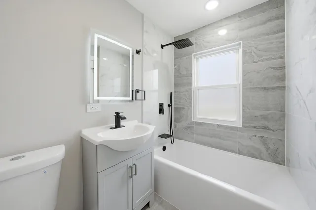 a bathroom with a sink mirror toilet and bathtub