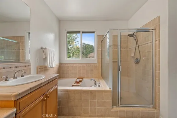 a bathroom with a granite countertop sink a mirror and a bathtub