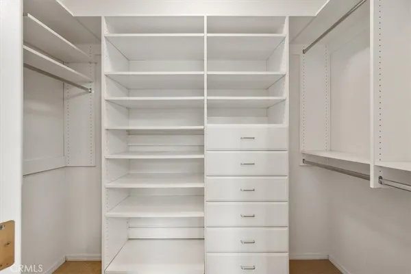a view of walk in closet with empty racks