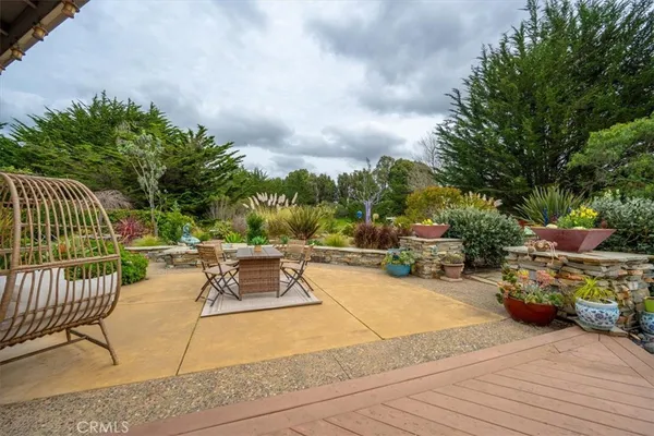 a view of a patio with dining table and chairs with wooden floor and fence