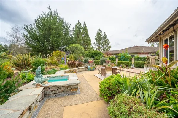 a view of a swimming pool with a patio and plants
