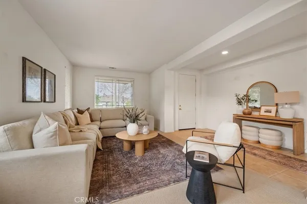 a living room with furniture a window and a piano