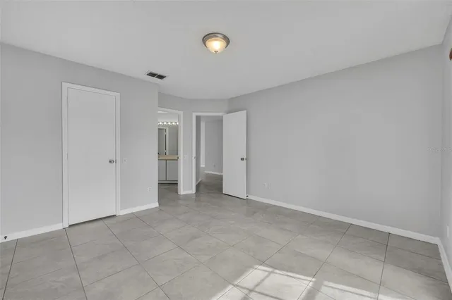 a view of an empty room with closet and entryway