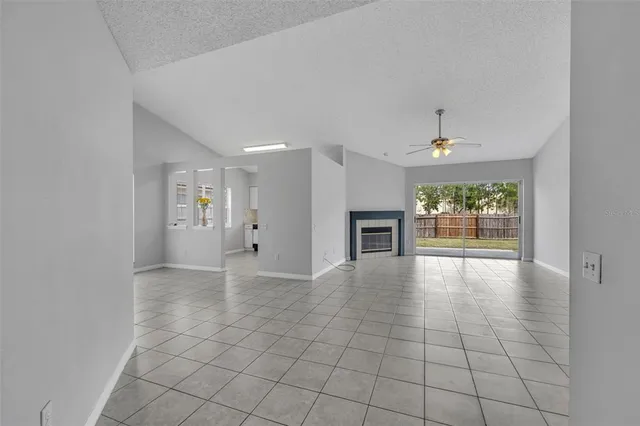 an empty room with windows and fireplace