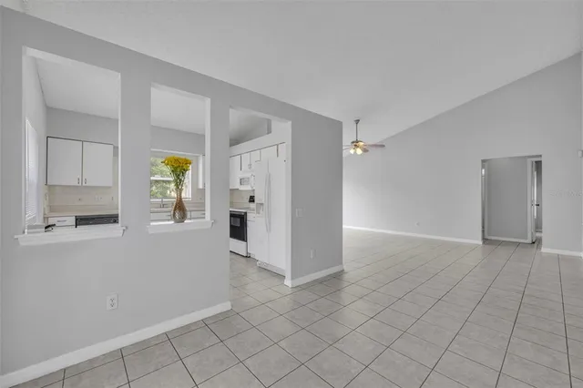 an empty room with windows and refrigerator