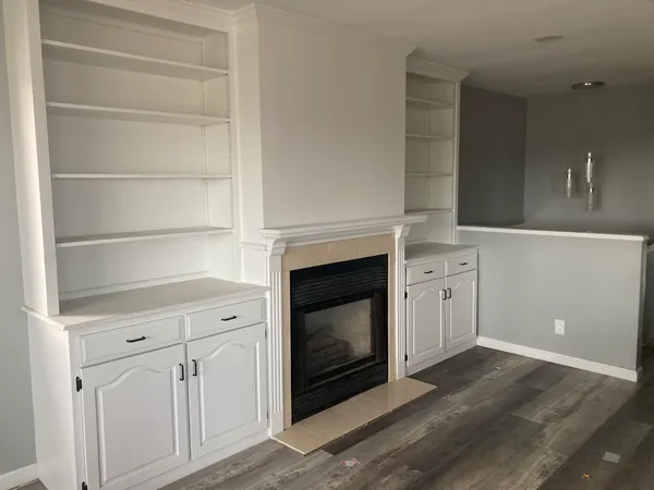 a view of an empty room with a fireplace and a window