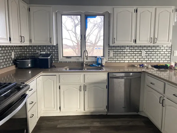 a kitchen with granite countertop white cabinets and white appliances
