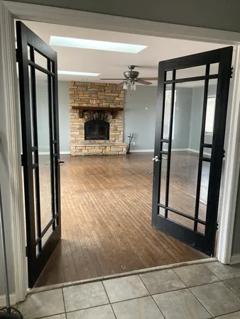 an empty room with wooden floor and a fireplace