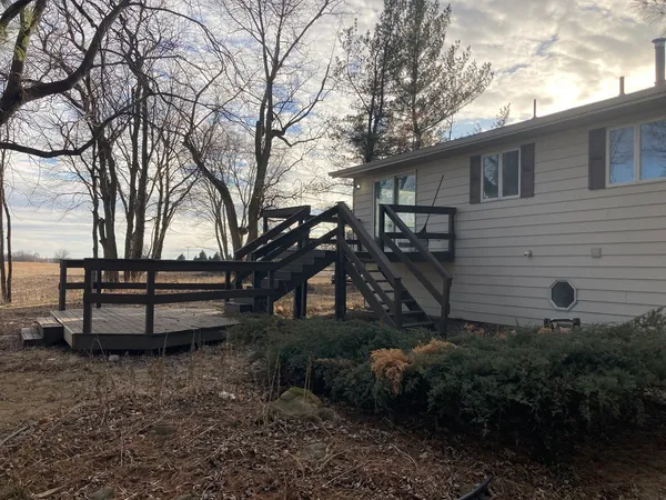 a backyard of a house with wooden fence and large trees