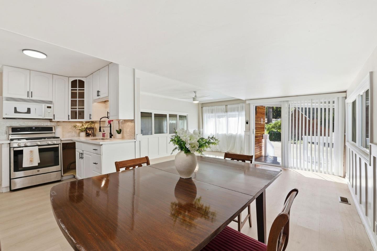265 Brown Gables Road, Unit 11 Ben Lomond, CA 95005 - Photo 14 of 50 a large white kitchen with stainless steel appliances granite countertop a stove a sink a dining table and chairs