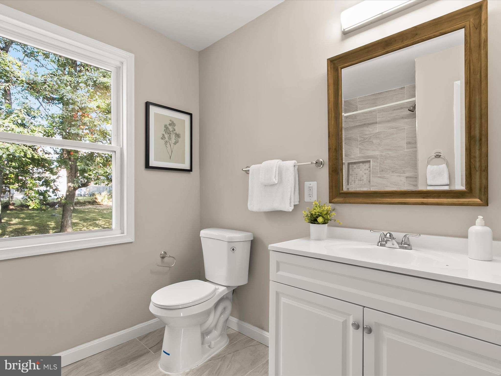 13211 Holdridge Road Silver Spring, MD 20906 - Photo 15 of 32 a bathroom with a toilet sink vanity and mirror