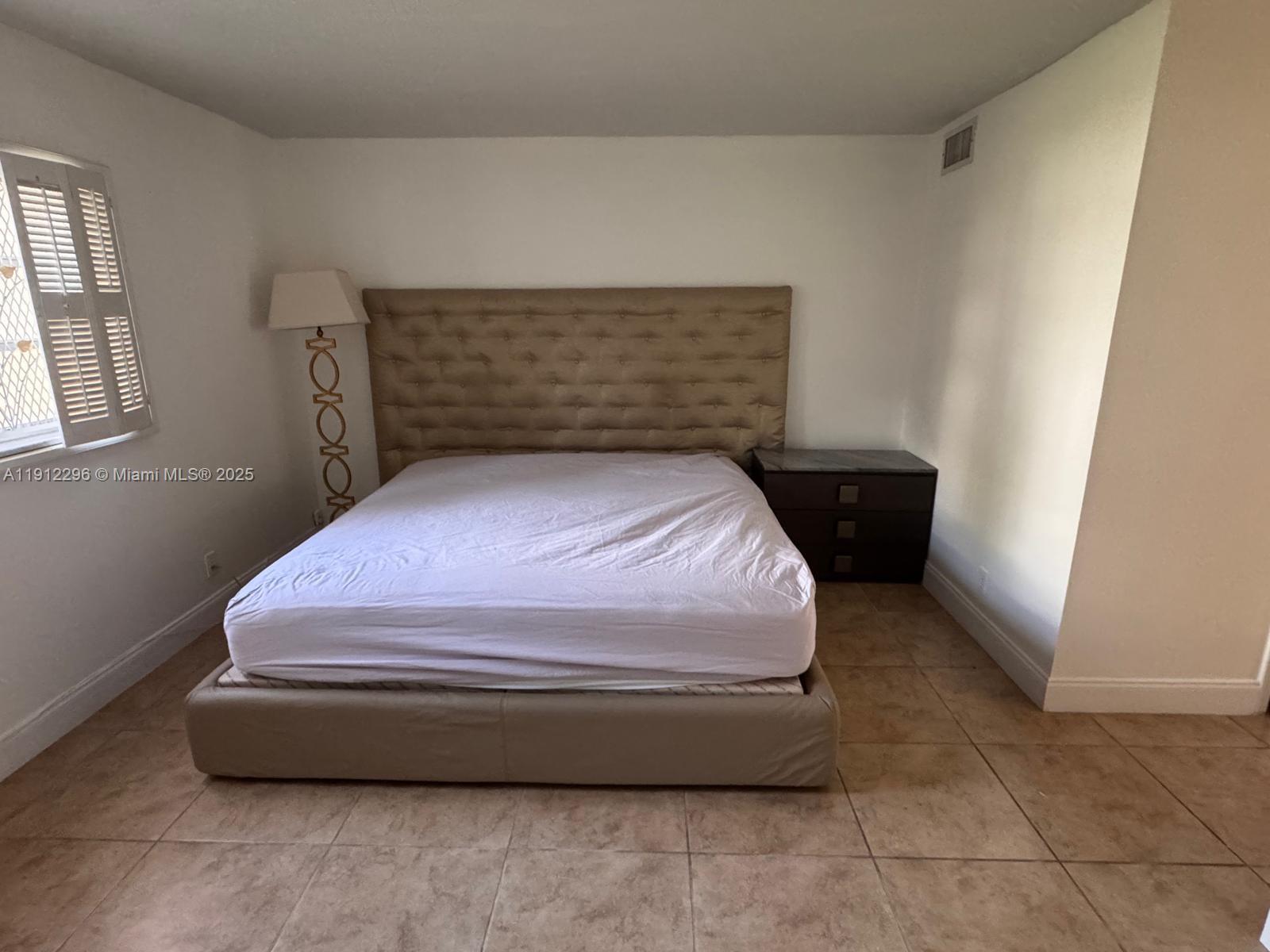 219 Northeast 14th Avenue, Unit 103 Hallandale Beach, FL 33009 - Photo 6 of 11 a room with a bed