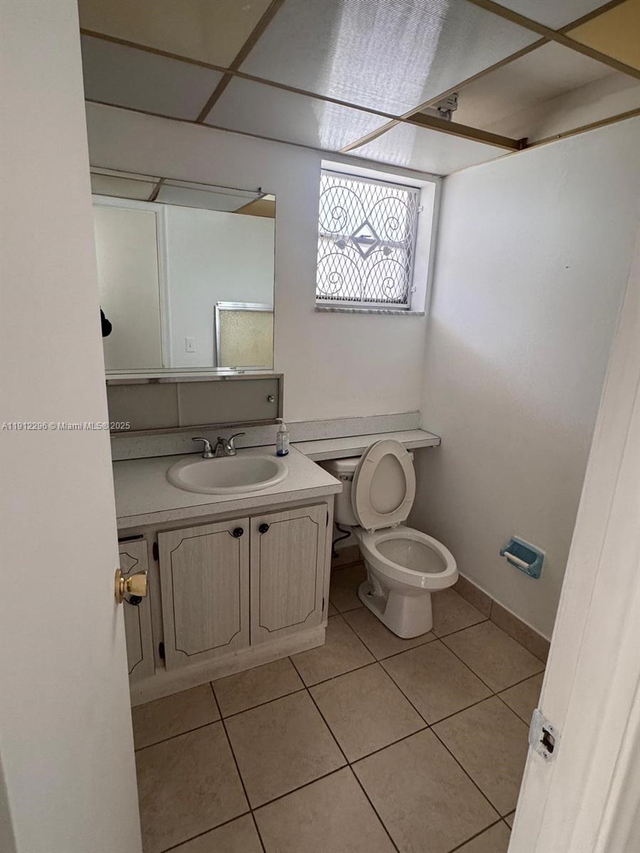 219 Northeast 14th Avenue, Unit 103 Hallandale Beach, FL 33009 - Photo 9 of 11 a bathroom with a toilet sink and mirror