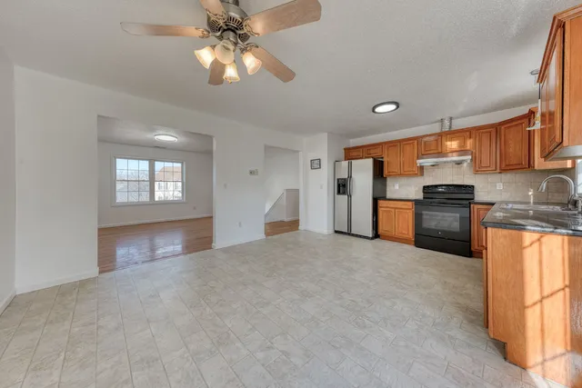 a view of a kitchen with a sink and a refrigerator