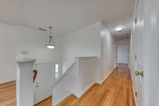 a view of hallway with stairs and wooden floor