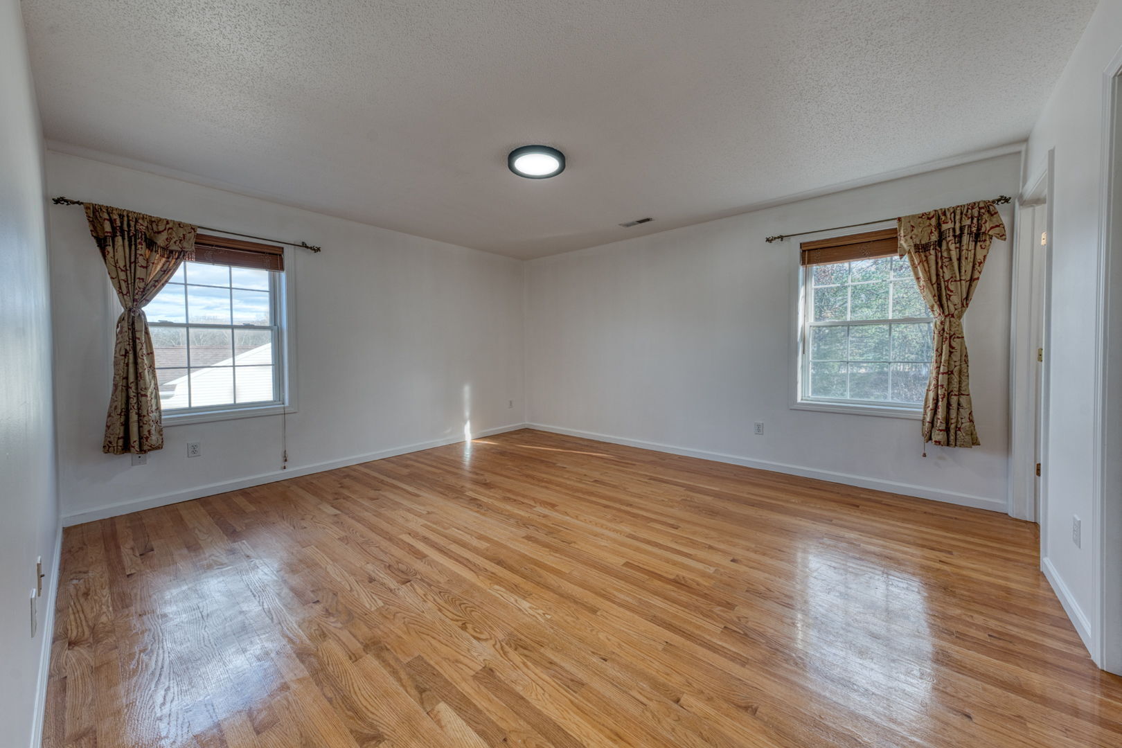 27 Aspen Place Windham, CT 06226 - Photo 18 of 39 an empty room with wooden floor and windows