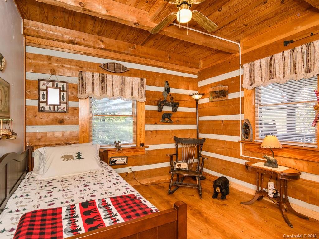 27 High Ridge Road Leicester, NC 28748 - Photo 14 of 24 a bedroom with a bed a table and chair