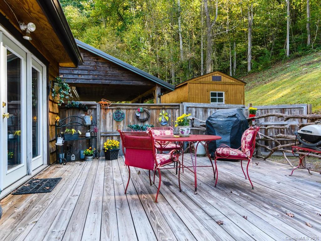 27 High Ridge Road Leicester, NC 28748 - Photo 23 of 24 a view of deck with table and chairs under an umbrella with wooden floor