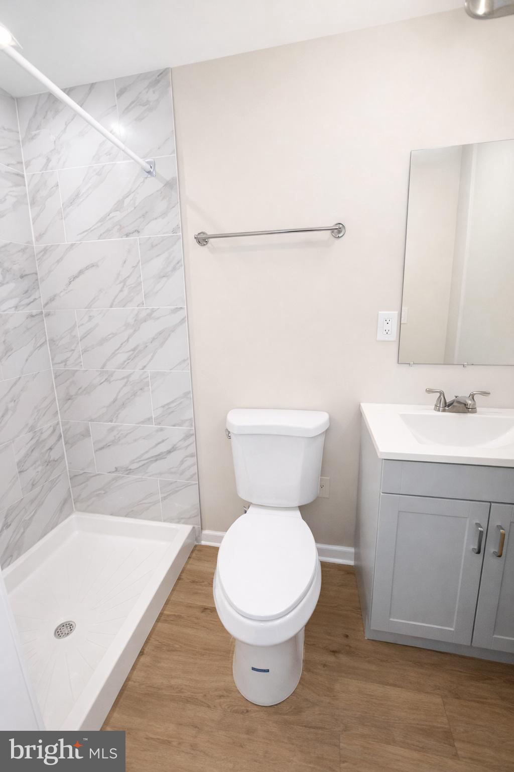 238 North Rose Street Baltimore, MD 21224 - Photo 4 of 7 a bathroom with a toilet a sink a mirror and vanity