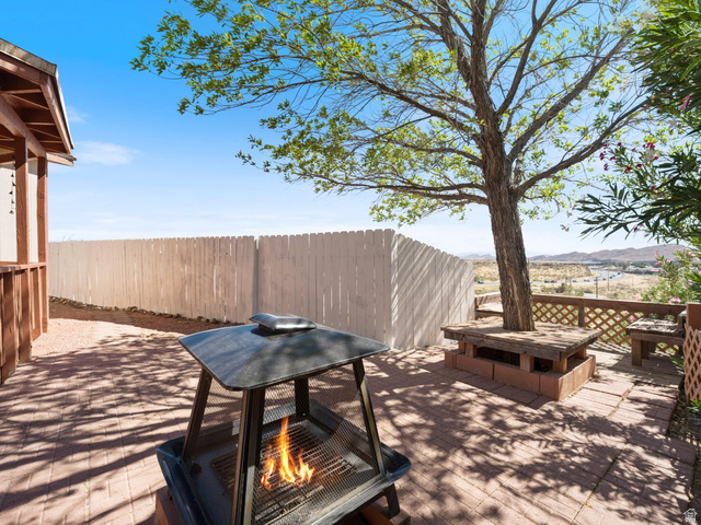 3941 West 40 North Hurricane, UT 84737 - Photo 49 of 55 Paver patio featuring a built-in tree surround with bench seating, a white picket fence, and distant mountain scenery