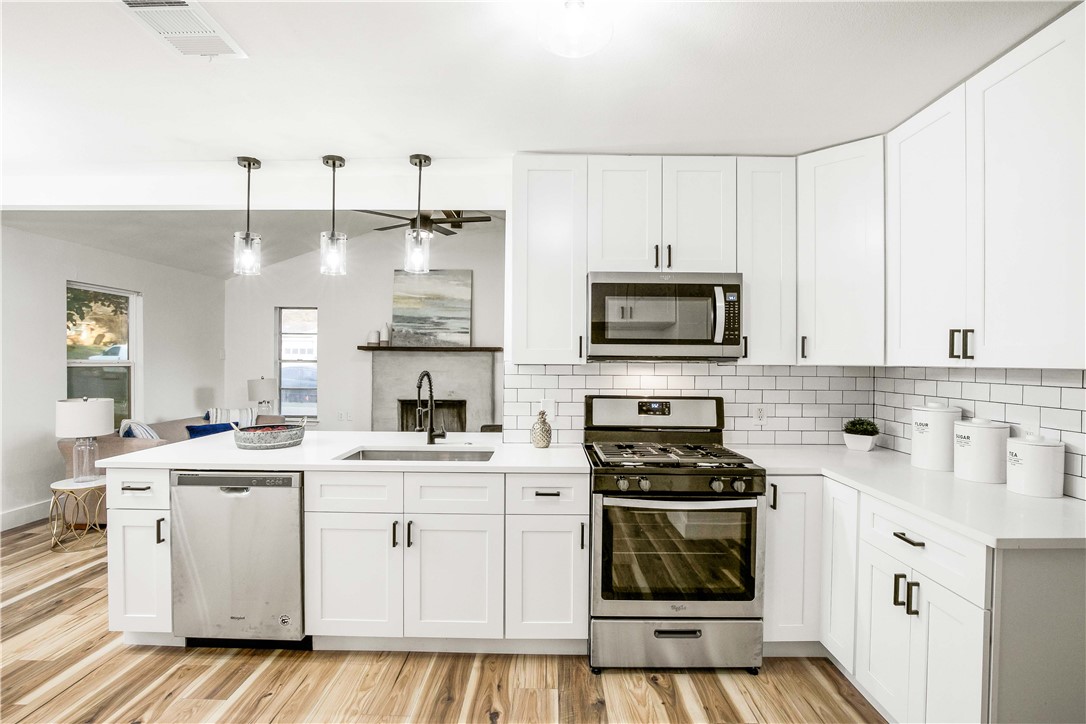 a kitchen with white cabinets stainless steel appliances and sink