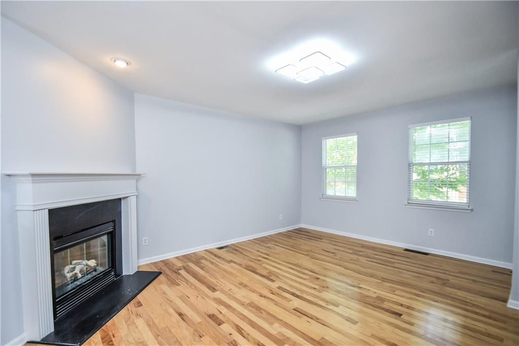 2201 Landing Walk Drive Duluth, GA 30097 - Photo 25 of 80 a view of empty room with wooden floor and fireplace