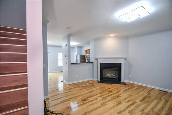 a view of an empty room with wooden floor and closet