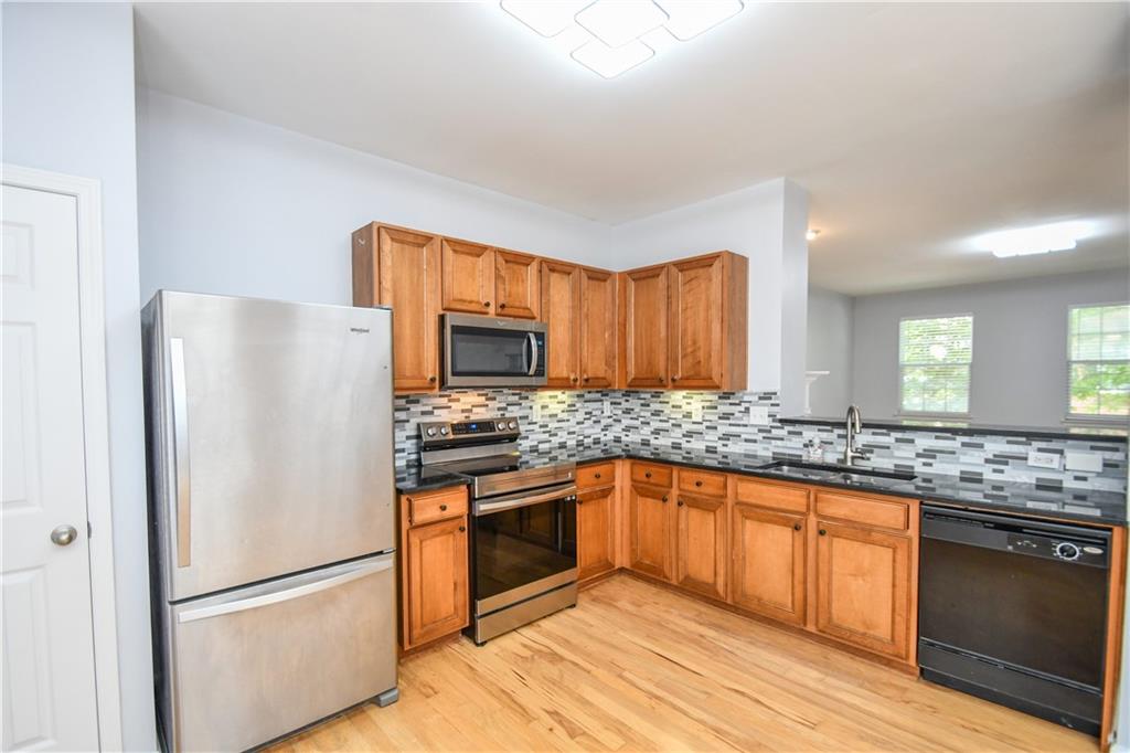 2201 Landing Walk Drive Duluth, GA 30097 - Photo 41 of 80 a kitchen with granite countertop stainless steel appliances and wooden cabinets