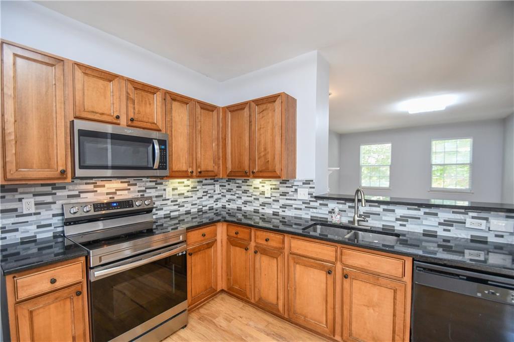 2201 Landing Walk Drive Duluth, GA 30097 - Photo 42 of 80 a kitchen with stainless steel appliances granite countertop a sink stove and microwave