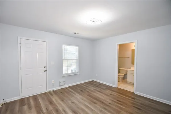 an empty room with a window and wooden floor
