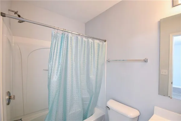 a bathroom with a tub sink and mirror