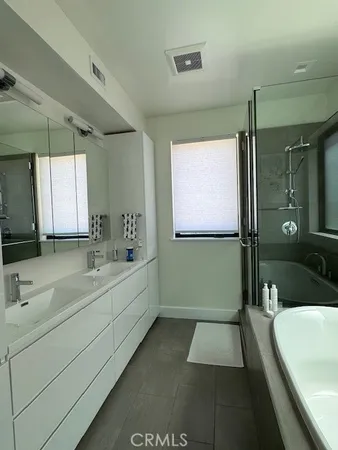 a bathroom with a tub a sink and mirror