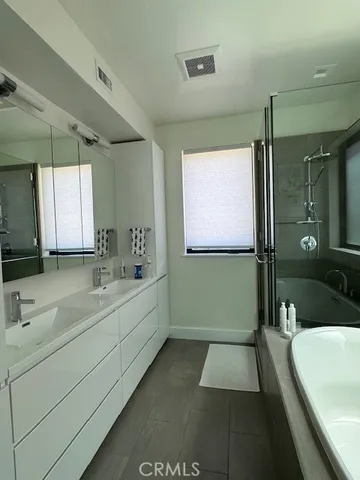a bathroom with a tub a sink and mirror