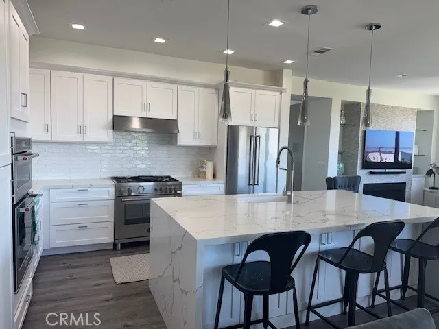 a kitchen with stainless steel appliances granite countertop a kitchen island a stove a table and chairs