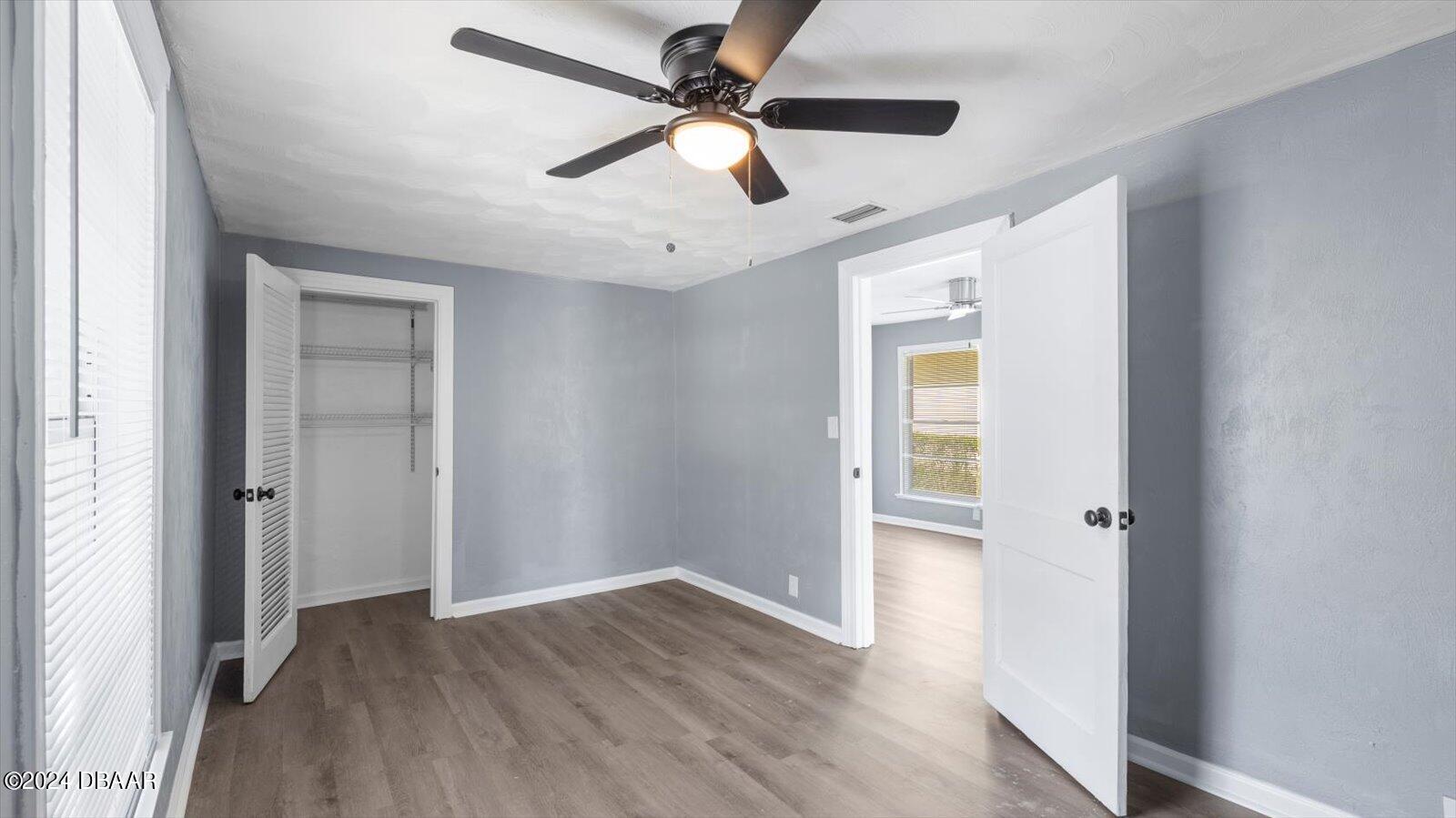 269 Selden Avenue Ormond Beach, FL 32174 - Photo 20 of 41 an empty room with wooden floor ceiling fan and windows