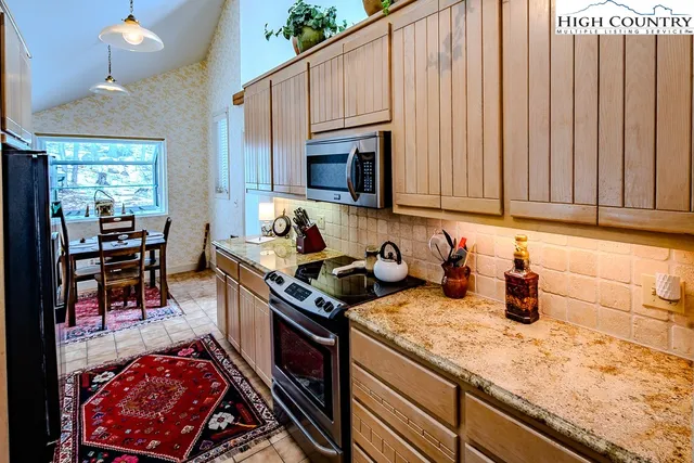 a kitchen with stainless steel appliances granite countertop a sink stove and cabinets