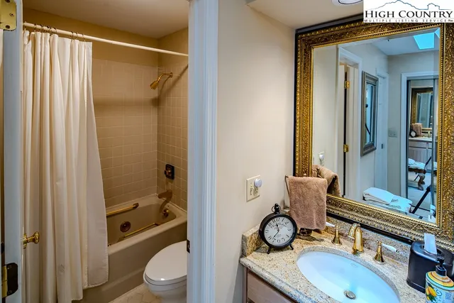 a bathroom with a granite countertop toilet a sink and a mirror