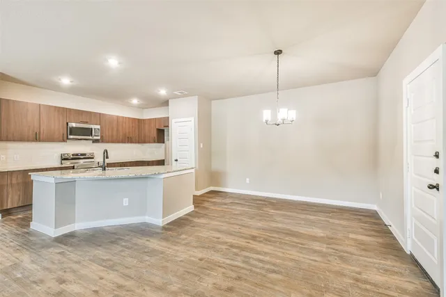 a kitchen with kitchen island a counter top space a sink appliances and cabinets