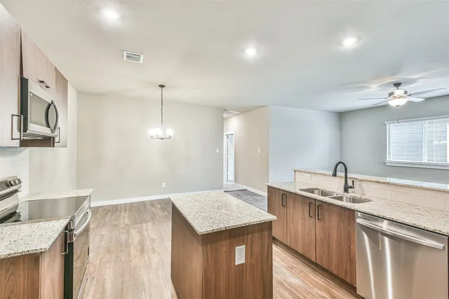 a kitchen with a sink a counter space and wooden floor