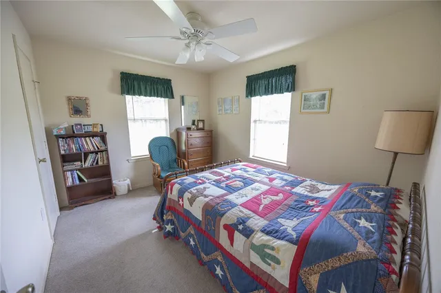 a bedroom with a bed a dresser and a window