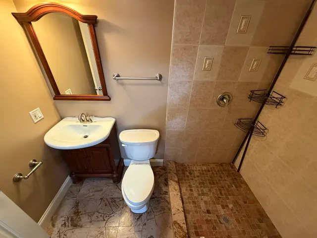 a view of kitchen with kitchen island stainless steel appliances refrigerator sink and cabinets