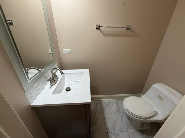 a bathroom with a sink toilet and mirror