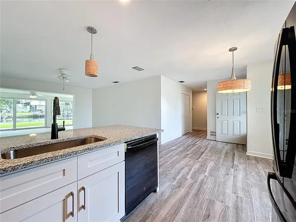 a kitchen with stainless steel appliances granite countertop a sink a stove and a wooden cabinets