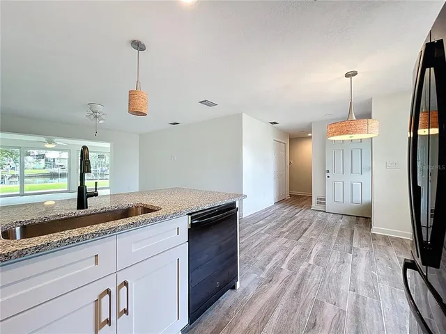 a kitchen with stainless steel appliances granite countertop a sink a stove and a wooden cabinets