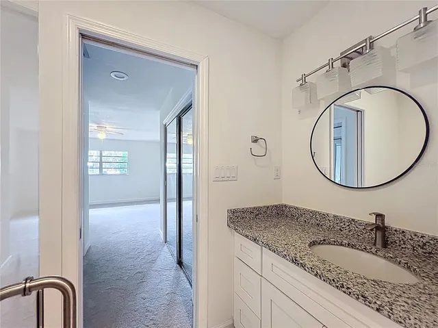 a bathroom with a granite countertop toilet sink and mirror