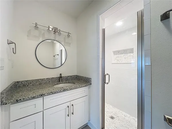 a bathroom with a granite countertop sink and a mirror