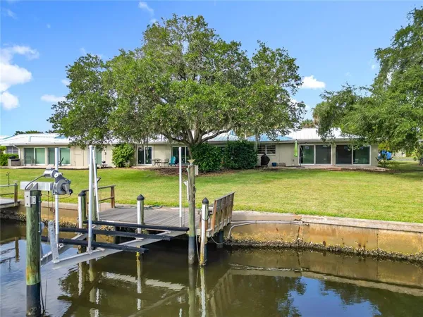 an aerial view of residential houses with outdoor space and lake view