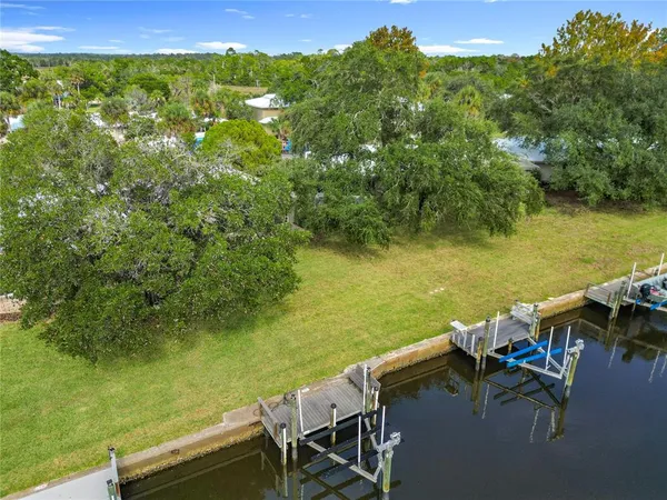 an aerial view of residential houses with outdoor space and lake view