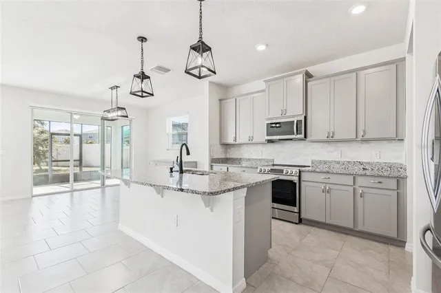 a large white kitchen with a stove a sink dishwasher a refrigerator and a oven with white cabinets