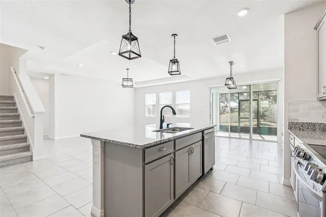 a kitchen with stainless steel appliances granite countertop a sink and dishwasher a stove top oven with wooden floor